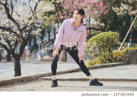 A woman stretching outdoors. Warming up before and after running. Healthy exercise habits. 137363449