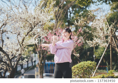 A woman stretching outdoors. Warming up before and after running. Healthy exercise habits. 137363450