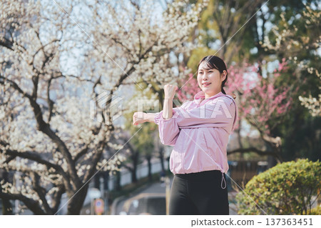 A woman stretching outdoors. Warming up before and after running. Healthy exercise habits. 137363451