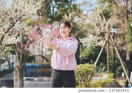 A woman stretching outdoors. Warming up before and after running. Healthy exercise habits. 137363453