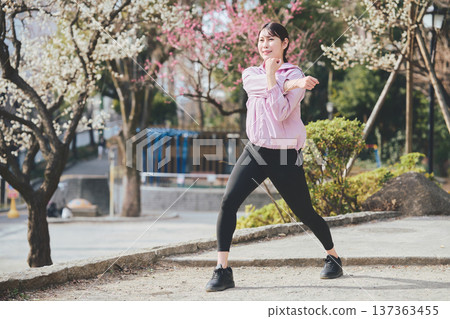 A woman stretching outdoors. Warming up before and after running. Healthy exercise habits. 137363455
