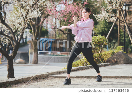 A woman stretching outdoors. Warming up before and after running. Healthy exercise habits. 137363456
