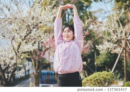 A woman stretching outdoors. Warming up before and after running. Healthy exercise habits. 137363457