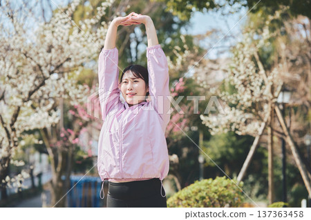 A woman stretching outdoors. Warming up before and after running. Healthy exercise habits. 137363458