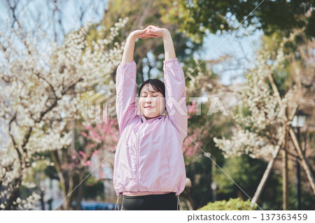 A woman stretching outdoors. Warming up before and after running. Healthy exercise habits. 137363459