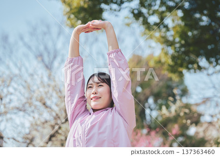 A woman stretching outdoors. Warming up before and after running. Healthy exercise habits. 137363460