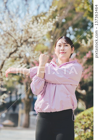 A woman stretching outdoors. Warming up before and after running. Healthy exercise habits. 137363464