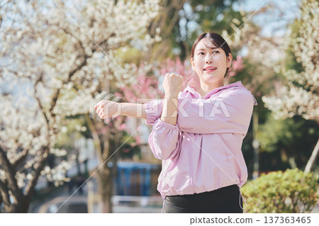 A woman stretching outdoors. Warming up before and after running. Healthy exercise habits. 137363465