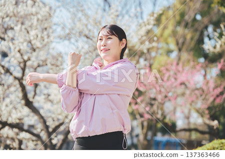 一位女士在戶外做伸展運動。跑步前後的暖身運動。健康的運動習慣。 一位女士在戶外做伸展運動。跑步前後的暖身運動。健康的運動習慣。 137363466