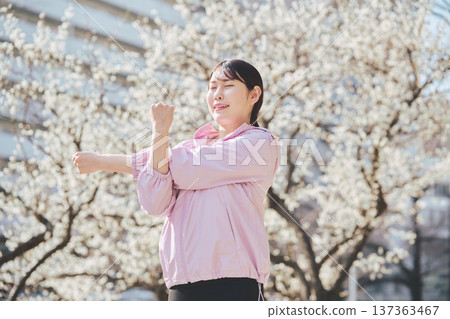 A woman stretching outdoors. Warming up before and after running. Healthy exercise habits. 137363467