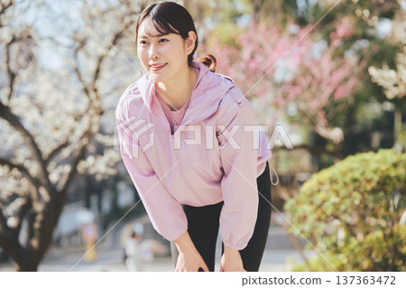A woman stretching outdoors. Warming up before and after running. Healthy exercise habits. 137363472