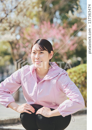 A woman stretching outdoors. Warming up before and after running. Healthy exercise habits. A woman stretching outdoors. Warming up before and after running. Healthy exercise habits. 137363474