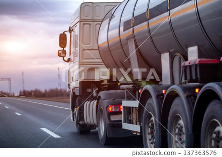 White semi-truck with dark tanker trailer transporting carbon dioxide on highway. Dangerous goods logistics and long-haul road freight movement. Copy space for text 137363576
