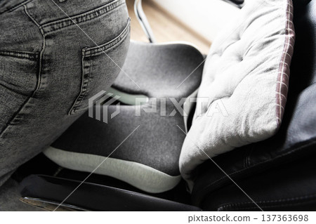 Orthopedic cushion providing back pain relief, posture correction, spinal support for disc herniation and osteochondrosis, person using 137363698