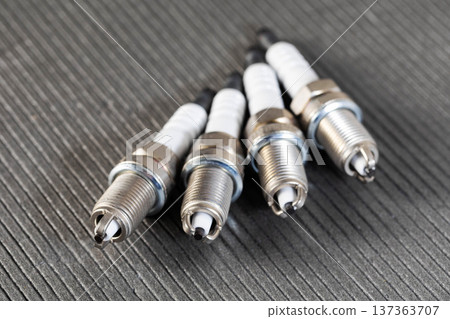 New automotive spark plugs for engine ignition system maintenance and car service. Close up view of metal and ceramic components. 137363707