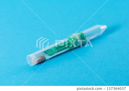 A stool sample tube on a blue background. Conceptual study of biomaterial for dysbiosis and pancreatic elastase. Copy space for text A stool sample tube on a blue background. Conceptual study of biomaterial for dysbiosis and pancreatic elastase. Copy space for text 137364037