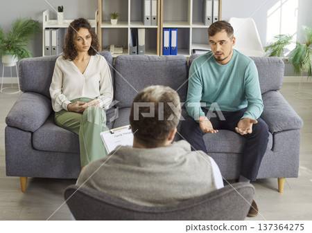 Couple meeting with doctor for discussion of diagnosis and treatment in medical clinic 137364275