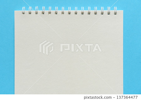 Blank spiral sketchbook on a bright blue background - top view Blank spiral sketchbook on a bright blue background - top view 137364477
