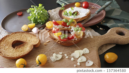 Round bruschetta with red and yellow cherry tomatoes and goat cheese on oak wooden board. Farm produce, crusty bread. Food and healthy eating. Round bruschetta with red and yellow cherry tomatoes and goat cheese on oak wooden board. Farm produce, crusty bread. Food and healthy eating. 137364580