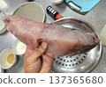 Close-up of a Person Holding a Large Fresh Raw Fish Fillet in a Kitchen 137365680
