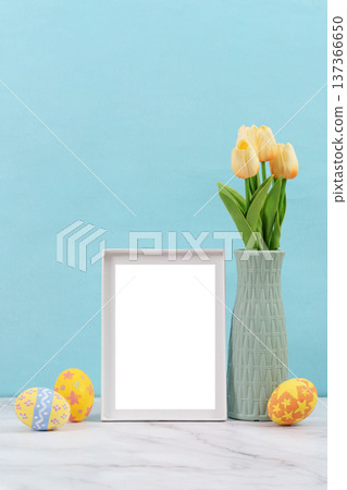 Easter Decor. Blank frame with tulips and colorful eggs on a blue background. 137366650