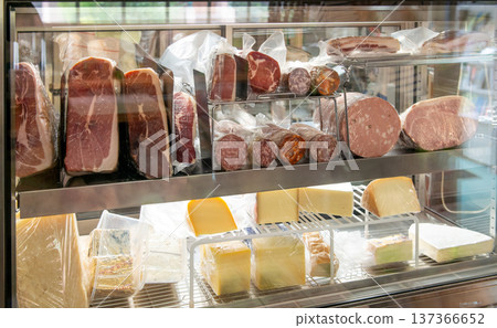 義大利雜貨店兼熟食店的展示櫃裡擺放著成塊的火腿和進口起司。 137366652