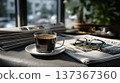 A Cozy Morning Scene with a Freshly Brewed Cup of Coffee, Newspaper, and Reading Glasses on a Table  137367360