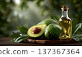 Fresh Avocados with Olive Oil on Wooden Board Surrounded by Greenery in Natural Lighting for Culinar 137367364