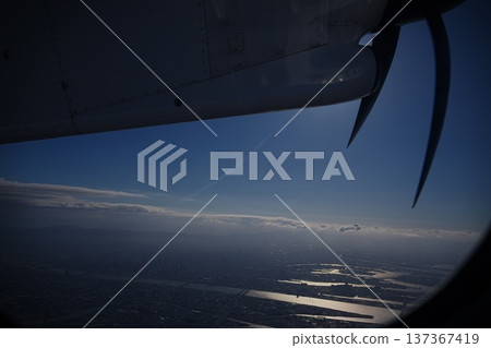 從螺旋槳飛機機翼上俯瞰海岸線和城市。 從螺旋槳飛機機翼上俯瞰海岸線和城市。 137367419