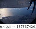 A glittering view of the sea and cityscape from an airplane window 137367420