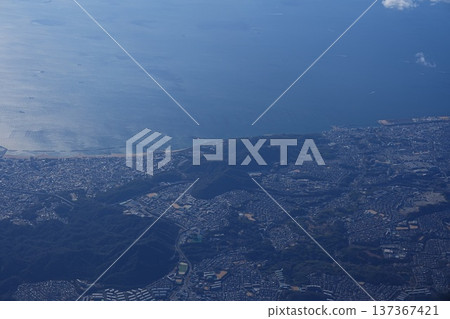 A glittering view of the sea and cityscape from an airplane window 137367421