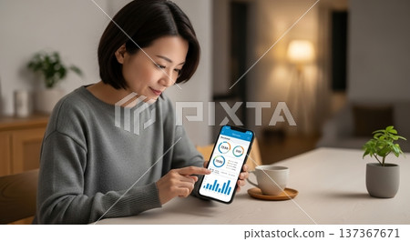 A woman analyzing data on a smartphone 137367671