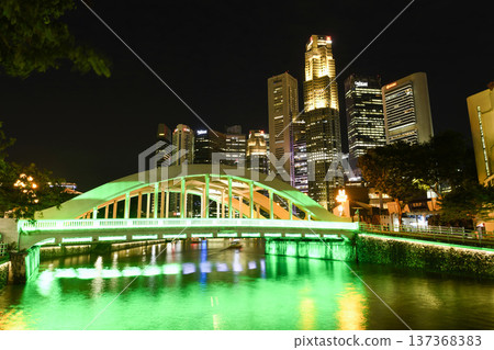 Night view of the Elgin Bridge in Civic District, Singapore, a vehicular box-girder bridge across the Singapore River, with a background of Financial District skyscrapers. 137368383