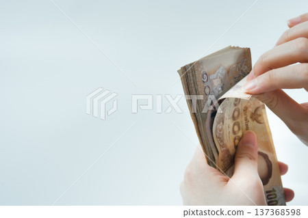 money income and invest concept with woman hand during count thai banknote on white isolated background money income and invest concept with woman hand during count thai banknote on white isolated background 137368598