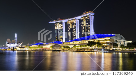 Night view of the Marina Bay Sands. This integrated resort fronts Marina Bay in Singapore. At night, there is an exhilarating music, light, and water dance show. 137369240