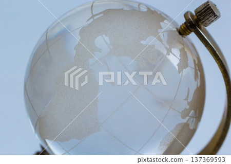 Globe highlighting continents with a vintage design resting on a simple stand in a softly lit room 137369593