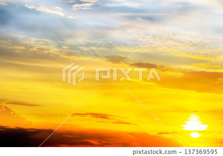 Vibrant sunset over a serene horizon showcasing brilliant hues of orange yellow and blue in the sky during early evening hours Vibrant sunset over a serene horizon showcasing brilliant hues of orange yellow and blue in the sky during early evening hours 137369595