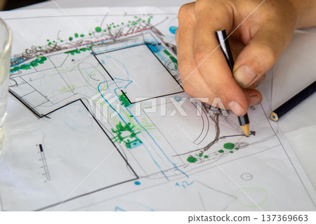 Landscape design sketch being created with colored pencils on a white sheet illustrating garden layout plants and pathways 137369663
