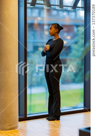 Woman looking through large window 137370189