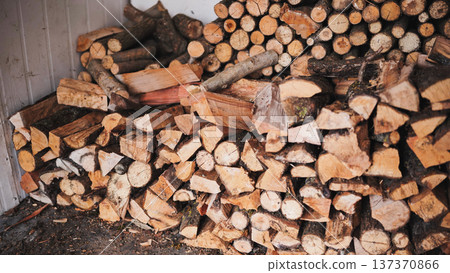 A man unloads firewood from a truck by hand. A man unloads firewood from a truck by hand. 137370866