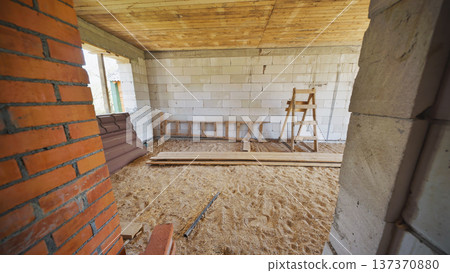Wooden ladder and trestle standing in house under construction 137370880