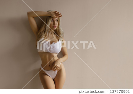 Sexy fitness beauty concept with slim woman posing in white lingerie, toned body and healthy lifestyle Sexy fitness beauty concept with slim woman posing in white lingerie, toned body and healthy lifestyle 137370901