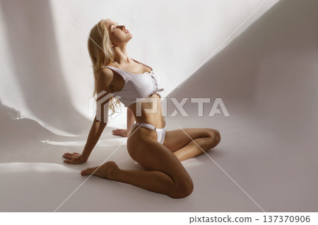 Sexy fitness beauty concept with slim woman posing in white lingerie in studio light, toned body and healthy lifestyle 137370906