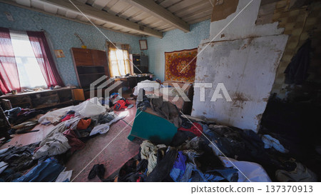 Neglected rural home interior with clothes and items scattered on floor Neglected rural home interior with clothes and items scattered on floor 137370913