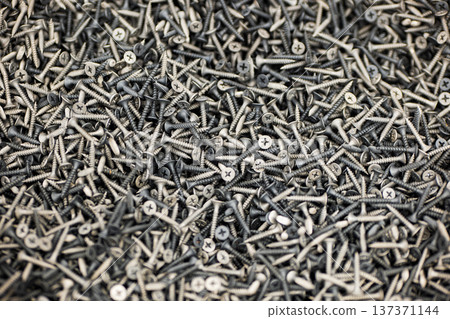 Many metal screws in a pile showing industrial texture and concept of connection or repair 137371144