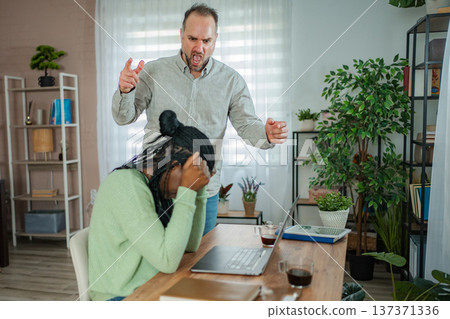 Man shouting at woman covering her ears during domestic conflict Man shouting at woman covering her ears during domestic conflict 137371336
