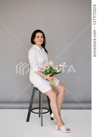Beautiful Professional Female Doctor Holding Pink Tulips Beautiful Professional Female Doctor Holding Pink Tulips 137372028