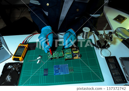 Close up of Technician measuring voltage electronic circuit board, Service after sale fix electric equipment. 137372742