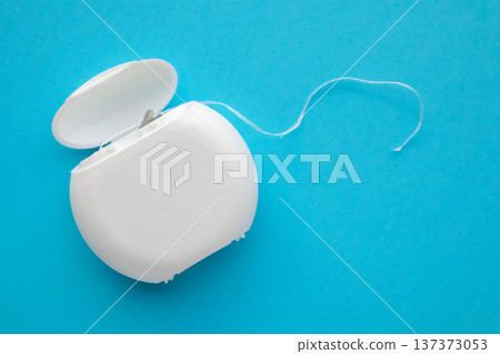 dental floss in case on blue background 137373053