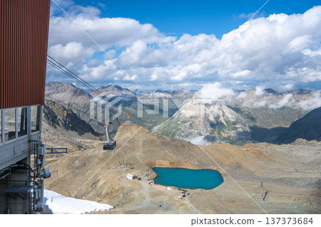 Travel on the Diavolezza Cable Car for stunning panoramic views of the Swiss Alps. Enjoy the breathtaking scenery of glaciers, peaks, and the tranquil alpine lake below. 137373684